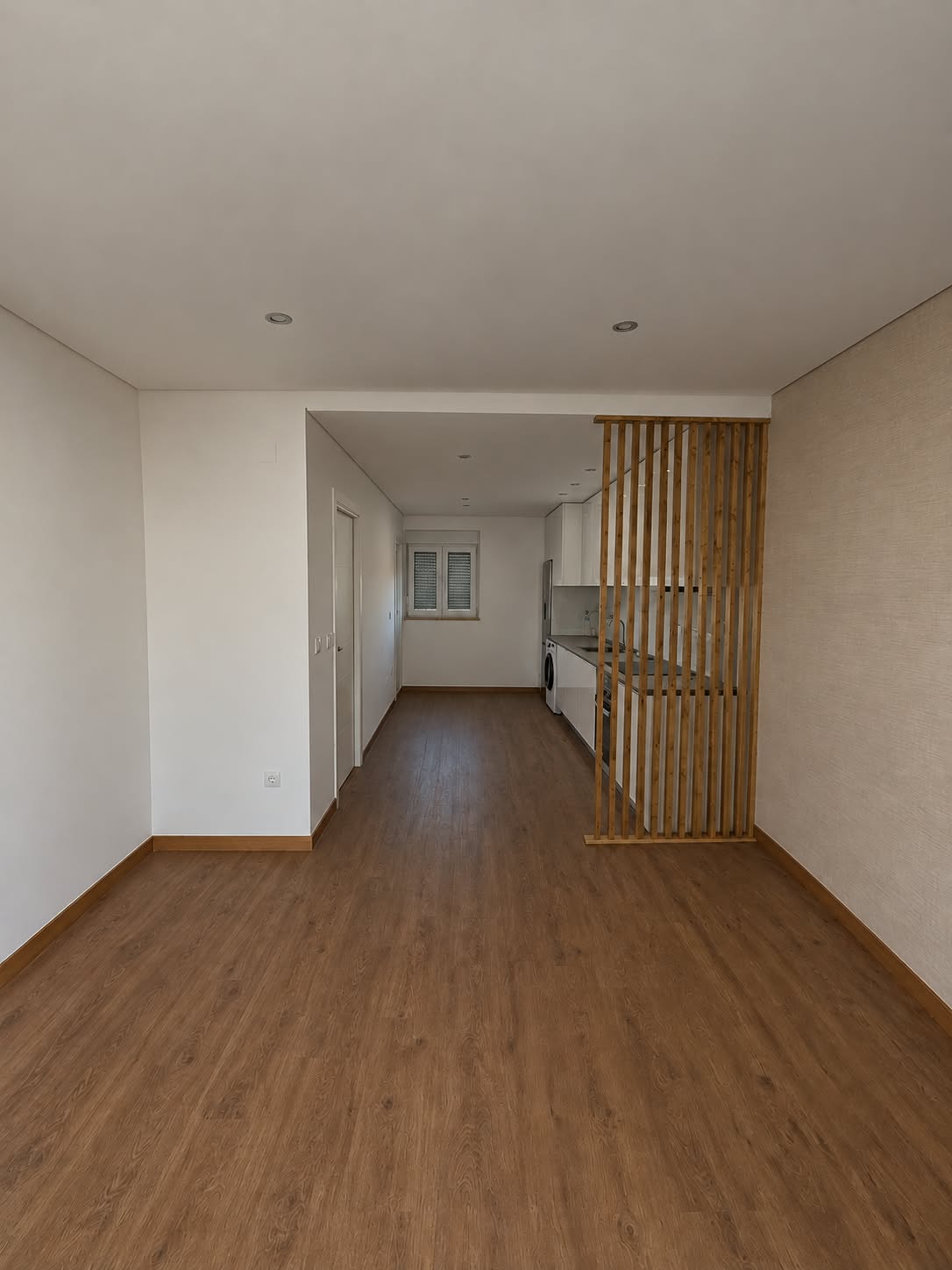 Sala e cozinha separadas por ripado de madeira